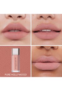 Lápiz labial líquido en un tubo transparente con tapa plateada, que muestra varios tonos de labios. Los colores varían desde un rosa suave hasta nude, con acabado mate y textura visible.