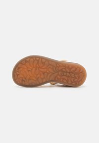 Suola di sandalo con un design testurizzato e decorativo; materiale in gomma marrone traslucido; presenta il logo e bordi curvi per maggiore flessibilità.