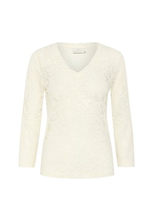 Top en dentelle crème avec un décolleté en V, des manches trois-quarts, des motifs floraux détaillés et une texture en relief.