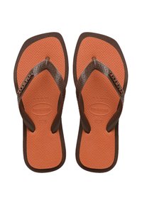 Tongs en caoutchouc marron avec semelle intérieure orange texturée. La sangle ajustable présente un motif en chevrons. La marque est visible sur la sangle.