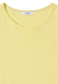 Pull à col rond jaune clair avec des détails de couture et une étiquette blanche affichant le nom de la marque "CECIL" au niveau de l'encolure.