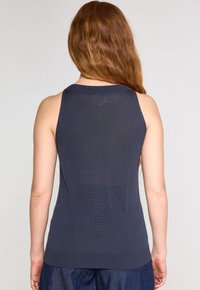 Top senza maniche di colore blu navy realizzato in tessuto a costine, con scollo rotondo e silhouette aderente caratterizzata da una leggera texture dell'orlo.
