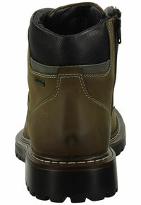 Botas de cuero marrón con un cuello de cuero negro, cremallera lateral, suela de goma y detalle de costura blanca a lo largo de los bordes.