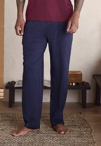 Męskie granatowe spodnie do salonu z lekkiego materiału, o luźnym kroju i prostych nogawkach. Wyposażone w prosty elastyczny pas.