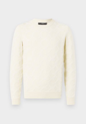 Pull en tricot crème avec un motif géométrique texturé. Doté d'un col rond, de manches longues et de poignets et un ourlet côtelés.