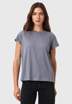 T-shirt grigio a maniche corte, vestibilità rilassata, con scollatura rotonda, realizzato in tessuto morbido con una sottile trama, abbinato a pantaloni neri.