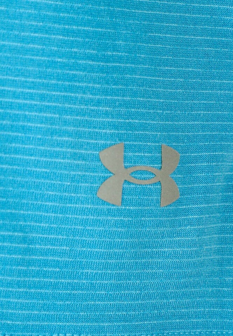 Tejido atlético azul claro con textura acanalada y un logo plateado en la parte frontal, que presenta un distintivo diseño de emblema superpuesto.