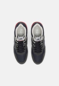 Marineblaue Sneakers mit grauen Akzenten, Obermaterial aus strukturiertem Stoff, gepolsterter Kragen, schwarze Schnürsenkel und weiße Sohle. Markenlogo auf der Zunge.