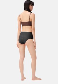 Bralette marrone con spalline regolabili e fascia con logo, abbinata a mutande nere a vita alta, tessuto morbido e design senza cuciture.