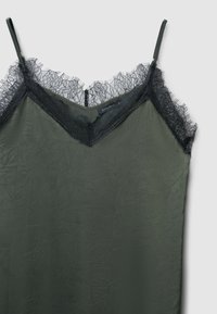 Abito in raso verde oliva con bordatura in pizzo nero lungo la scollatura e le spalline, caratterizzato da una texture arricciata e un'etichetta vicino alla parte superiore.