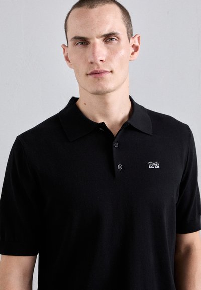 Zwarte polo shirt van katoen, met een kraag en drie knopen. Logo "D2" in het wit weergegeven op de linkerkant van de borst.
