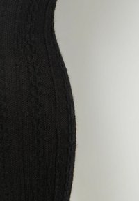 Sort strikket kjole med et struktureret kabelmønster, tætsiddende design og blødt stof, der fremhæver en glat silhuet.