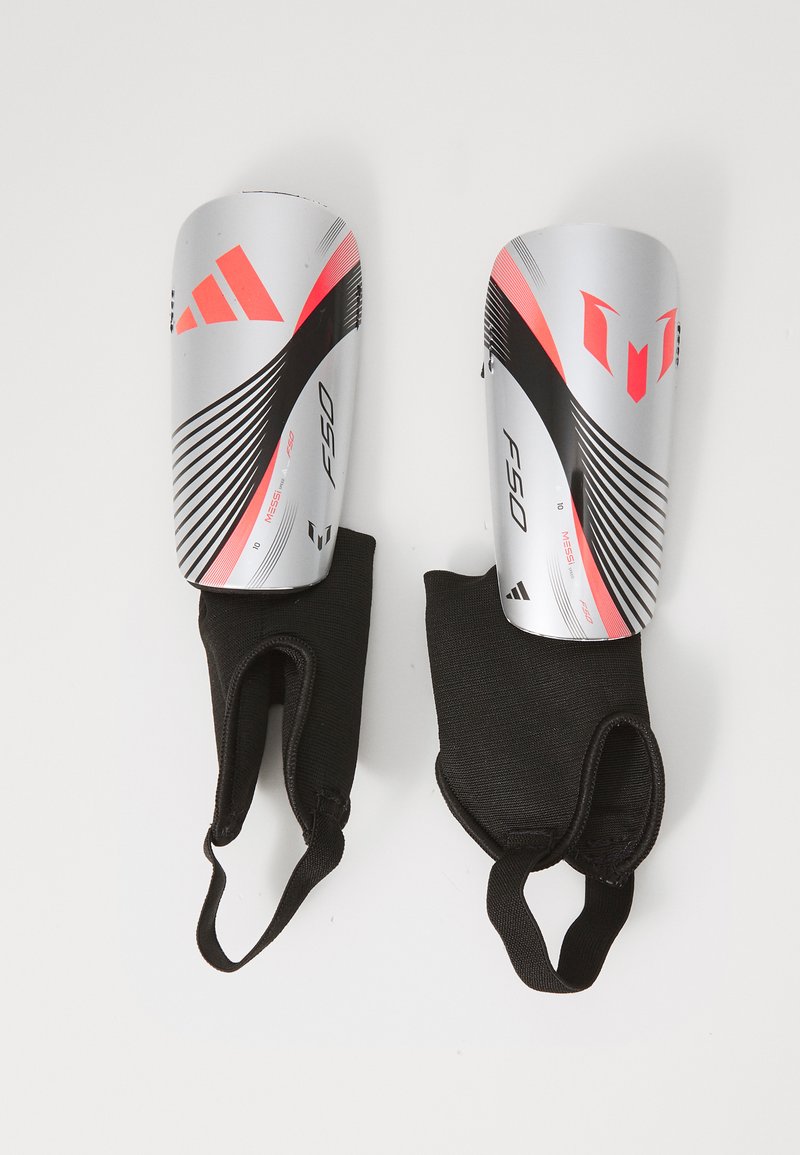 Srebrne i różowe ochraniacze na golenie do piłki nożnej z czarnymi elastycznymi rękawami; posiadają wyraźne graficzne linie i logo; lekkie wykonanie zapewniające ochronę.