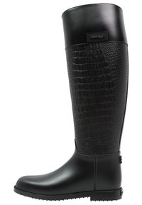 Botas de goma negras hasta la rodilla que presentan un patrón texturizado parecido a la piel de reptil en la parte superior, un acabado suave en la sección inferior y detalle del logotipo.