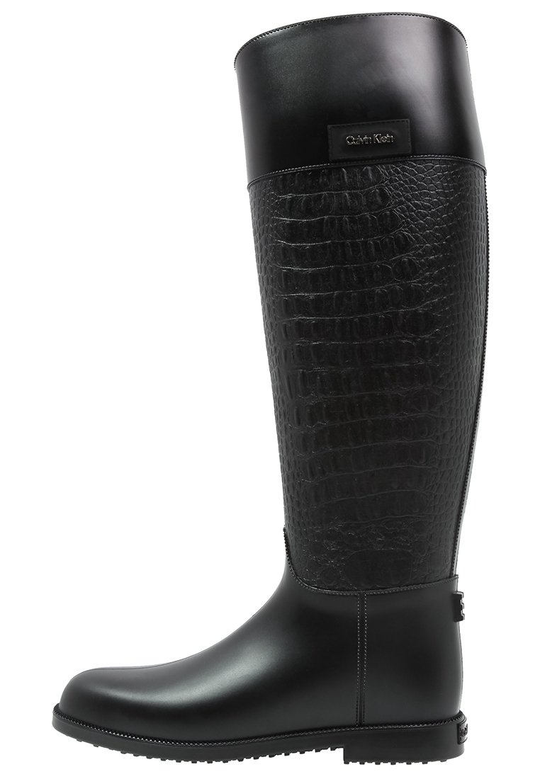 Botas de goma negras hasta la rodilla que presentan un patrón texturizado parecido a la piel de reptil en la parte superior, un acabado suave en la sección inferior y detalle del logotipo.