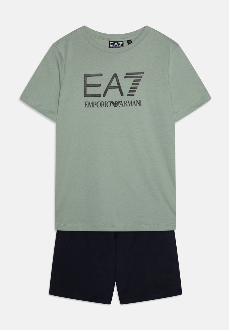 T-shirt in cotone verde chiaro con logo EA7 Emporio Armani nero, abbinato a pantaloni corti in cotone blu navy con un logo discreto sull'orlo.