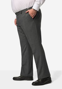Grijze broek met een regular fit, zachte textuur, zijzakken en een tailleband met een riem. Gecombineerd met zwarte schoenen.