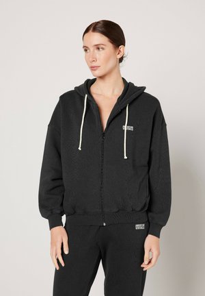 Zwarte rits hoodie met een trekkoordcapuchon, ribgebreide boorden en zoom, voorzien van een klein logo op de borst en een zachte, gestructureerde stof.