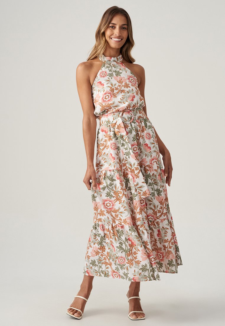 Robe maxi florale avec décolleté halter, présentant un corsage ajusté, une jupe à volants et une ceinture en tissu. Les couleurs incluent le rose, le vert et le blanc.