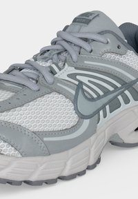 Γκρι και λευκό παπούτσι για τρέξιμο Nike με ύφασμα από δίχτυ, συνθετικές επικαλύψεις, κλείσιμο με κορδόνια και παχιά επενδεδυμένη σόλα.