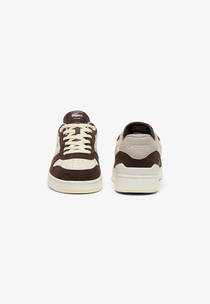 Paar braune und beige Lacoste-Sneaker, vorne und hinten auf weißem Hintergrund gezeigt.