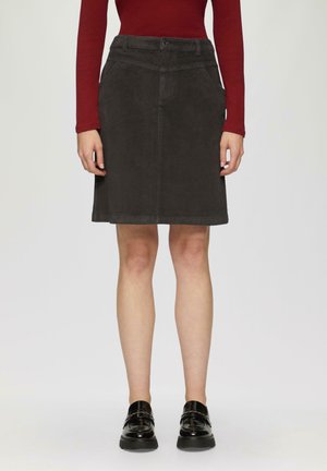 Grijze corduroy rok met een rechte snit, zijzakken en riemlussen. Gestyled met een strakke rode lange mouwtop en zwarte schoenen.