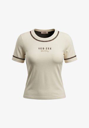 T-shirt crema a maniche corte con scollo rotondo, rifinita con motivo a catena marrone su collo e maniche, con scritta "YES ZEE Natural Feeling" sul davanti.
