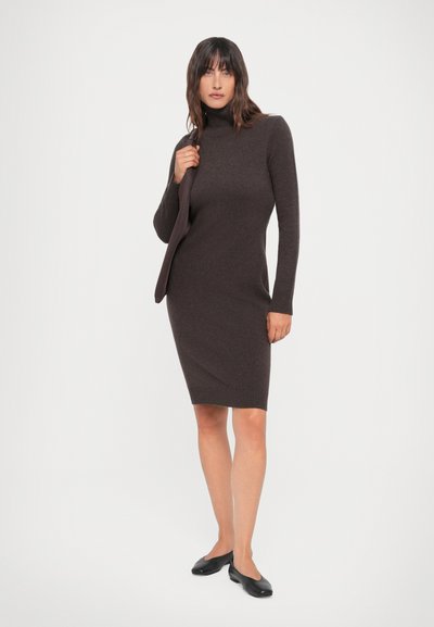 Rochie tricotată de culoare maro, cu guler înalt, mâneci lungi, design ajustat, până la genunchi, asortată cu un sacou similar, de culoare solidă, cu manșete cordonate.
