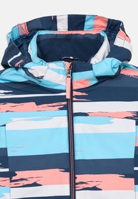 Farebná nepremokavá bunda s kapucňou, horizontálnymi modrými, bielymi a koralovými pruhmi a centrál zipsom so chráničom brady.