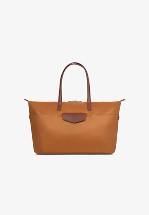 Grand sac fourre-tout rectangulaire beige avec des poignées en cuir marron foncé et une poche avant à rabat sur un fond blanc.