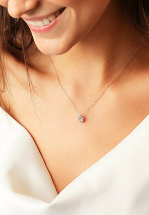 Silver chain necklace featuring a clear teardrop pendant. The pendant has a sparkling finish with a smooth texture.