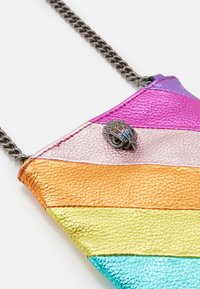 Kovová kožená kabelka přes rameno s horizontálními pruhy v růžové, fialové, oranžové, žluté a tyrkysové barvě s ozdobnou sponou. Součástí je řetízkový popruh.