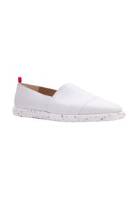 Scarpe slip-on bianche in pelle con punta affusolata, dotate di una suola bianca maculata e di un piccolo etichetta rossa di stoffa sul retro.
