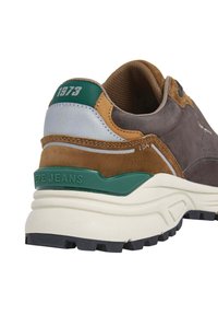 Sneaker in suede e pelle marrone con accenti verdi e argento. Soletta bianca spessa, suola grigia testurizzata e branding "PEPE JEANS" sul tallone.