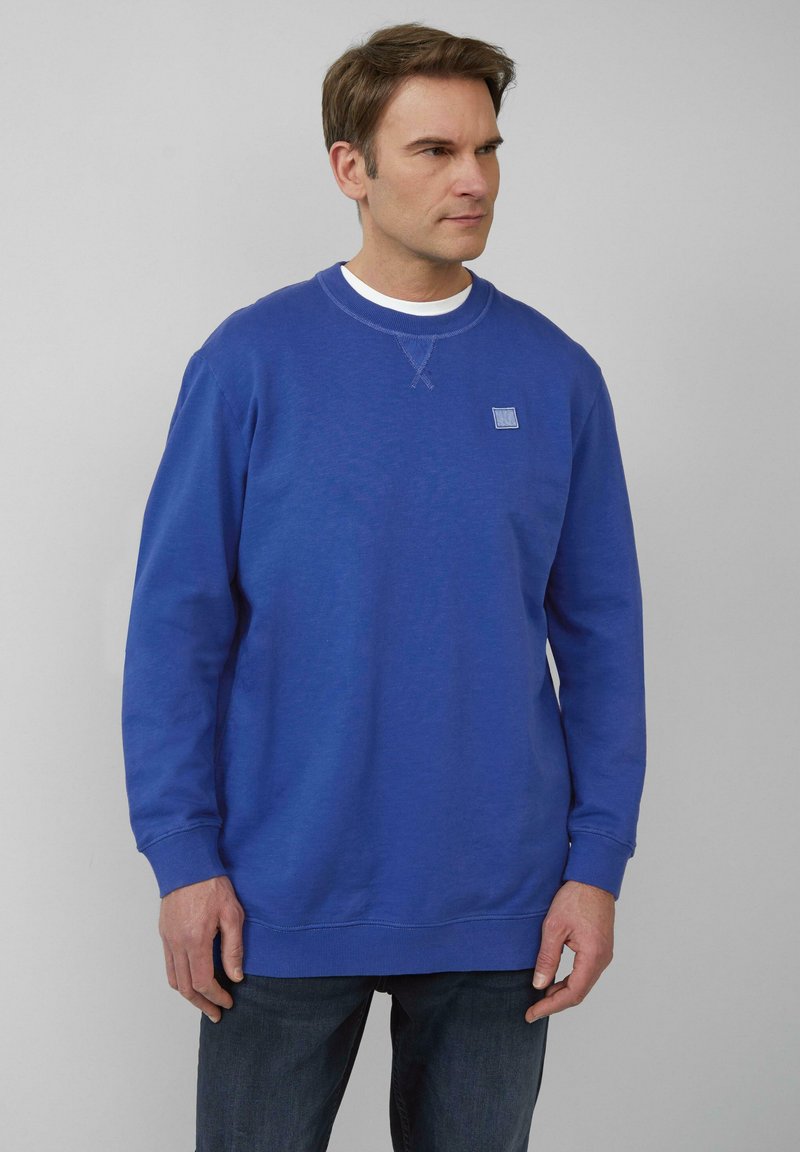 Sweatshirt bleu en tissu doux, à col rond, à manches longues, avec un petit logo brodé sur la zone de la poitrine gauche.