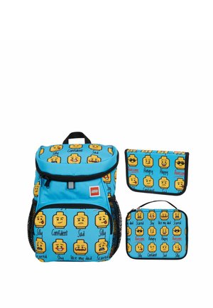 Sac à dos bleu LEGO et pochettes imprimés avec des têtes LEGO jaunes montrant différentes émotions et des étiquettes de texte telles que heureux, triste et confiant.