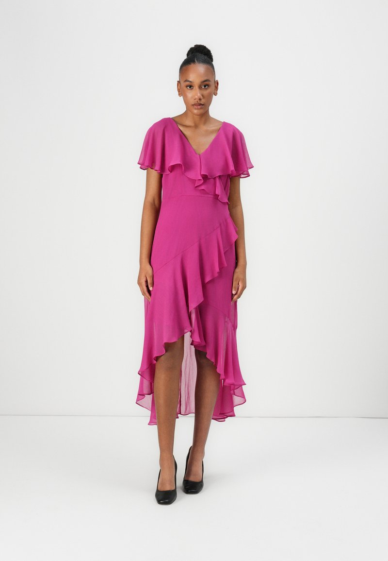 Robe fuchsia avec des manches à volants et un ourlet asymétrique. Fabriquée en tissu léger, elle présente un col en V et un design en couches.