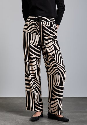 Pantaloni a gamba larga neri e beige con un motivo geometrico a righe, dotati di una vita elasticizzata e cordoncino. Tessuto morbido al tatto.