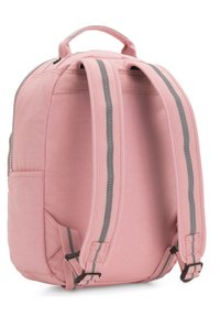 Mochila rosa con una tela texturizada, correas a rayas grises y un asa superior. Cuenta con un cierre de cremallera y un bolsillo lateral.