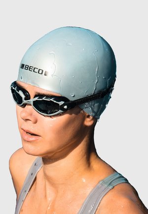 Helleblaue Silikon-Schwimmhaube mit "BECO"-Logo, kombiniert mit schwarzen Schwimmbrillen mit grauen Akzenten und einem sicheren Riemen. Wassertropfen sind sichtbar.
