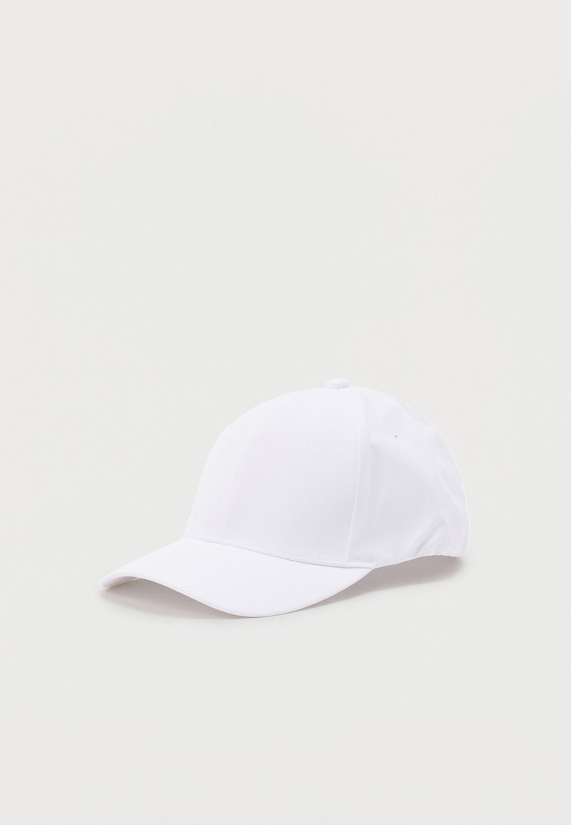 Casquette de baseball blanche unie avec visière courbée, couronne à six panneaux et petit bouton en tissu sur le dessus, posée sur une surface claire.