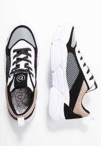 Scarpe da ginnastica atletiche nere e bianche con pannelli in mesh, sovrapposizioni testurizzate, linguetta imbottita e suole bianche spesse. Interno con fodera a motivo.