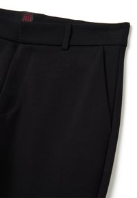 Zwarte broek met een gladde textuur, voorzien van platte voorplooien, zijzakken en een tailleband met een rood label.