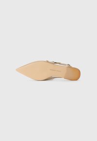 Beige high-heeled shoe with a pointed toe, clear straps, and a smooth sole. Features a modest heel and subtle logo on the insole.