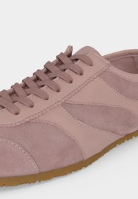 Baskets en daim et cuir rose clair avec semelle en gomme texturée et lacets assortis rose clair, vues de profil.