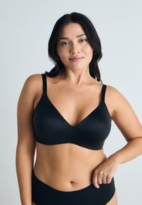 Black underwire bra with a smooth texture, V-neck design, and adjustable straps, paired with a matching bikini bottom.