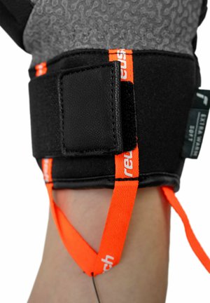 Black and grey adjustable glove with textured surface, featuring orange straps and Velcro closures for secure fit and ease of use.