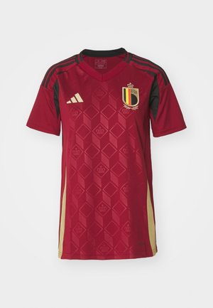 Camiseta de fútbol roja con un patrón geométrico de rombos, acentos en negro y un escudo con rayas amarillas y negras, fabricada con tejido ligero.
