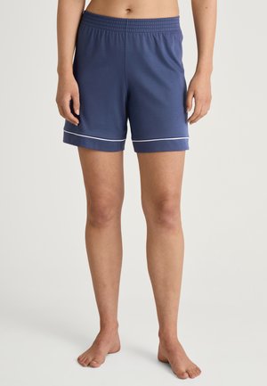 Marineblauwe katoenen shorts met elastische tailleband. Voorzien van witte biesdetails aan de onderrand. Ontworpen voor comfort en bewegingsgemak.