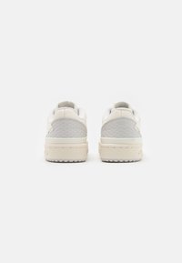 Białe sneakersy z szarymi akcentami, górna część z gładkiej skóry i teksturowane pięty, z grubą podeszwą i minimalistycznym wzornictwem.